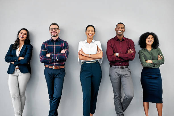 Studio shot of a group of businesspeople standing in line against a grey background